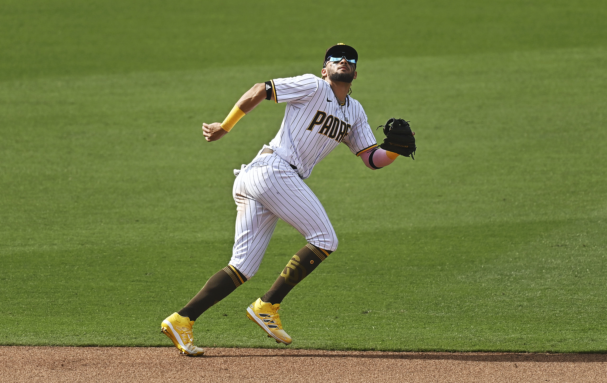 Padres’ Fernando Tatis Jr. chases a flyball into the outfield grass.